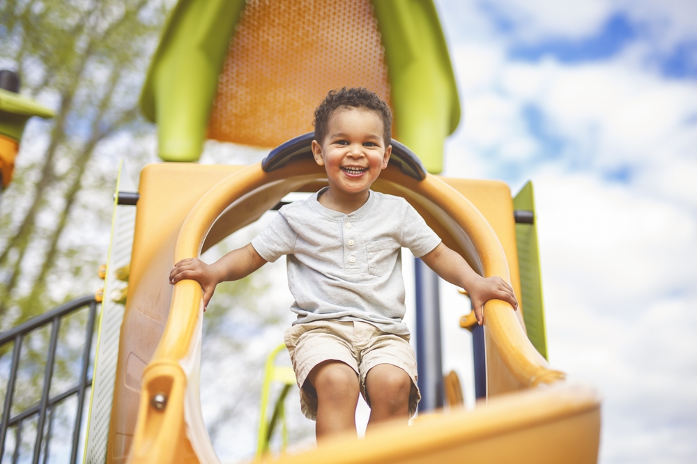 Child smiling going down slide